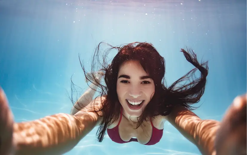 Woman underwater filed with joy taking a selfie